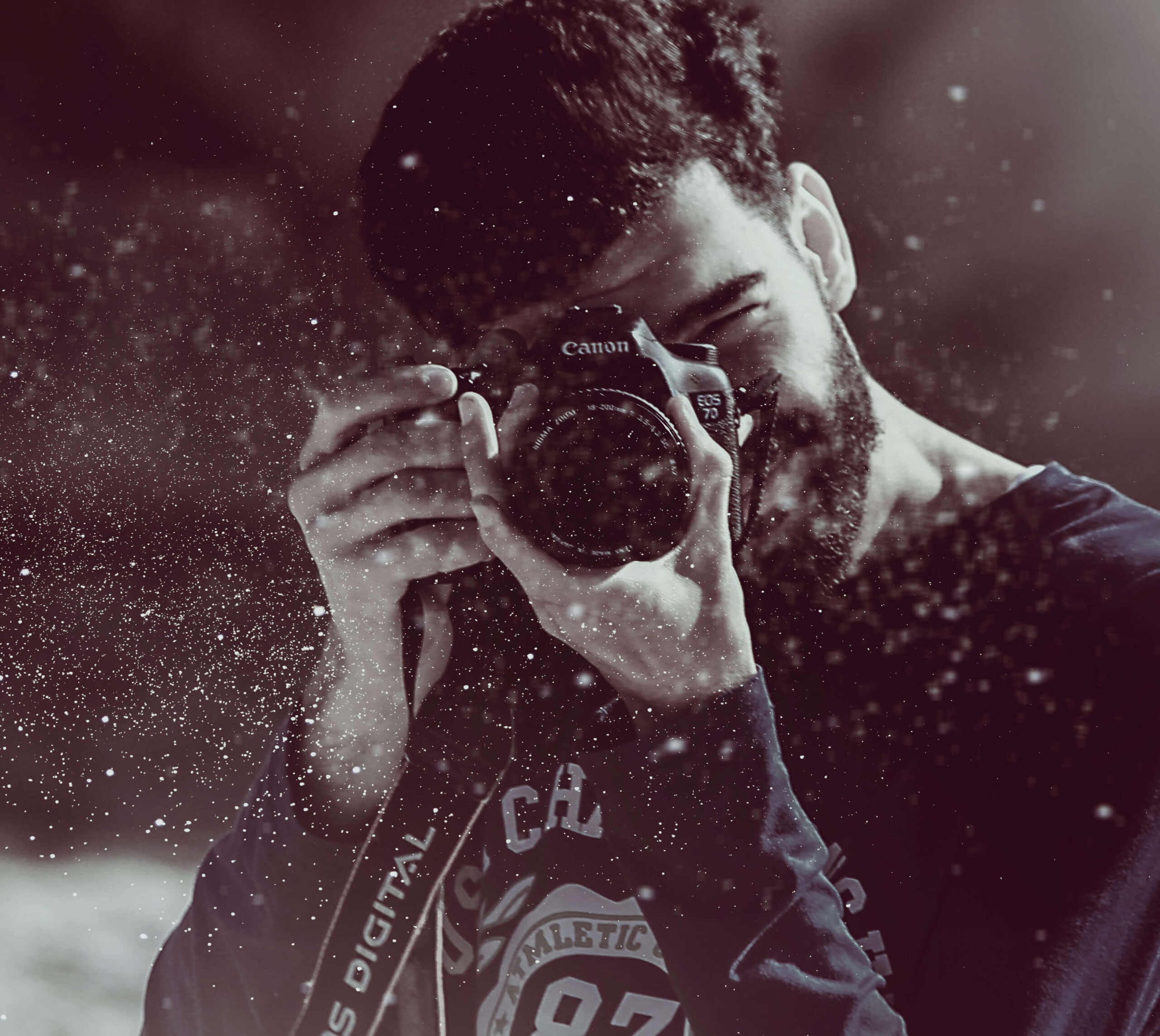 Photo of man looking through a camera